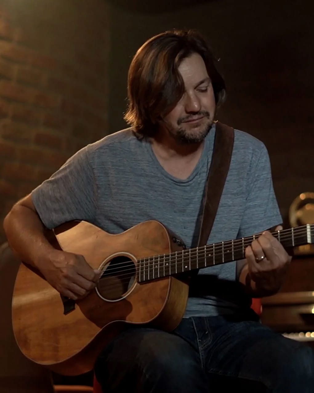 Daniel Mead seated with his Taylor acoustic guitar in the live room at Estúdio Casa das Máquinas, Salvador, Bahia